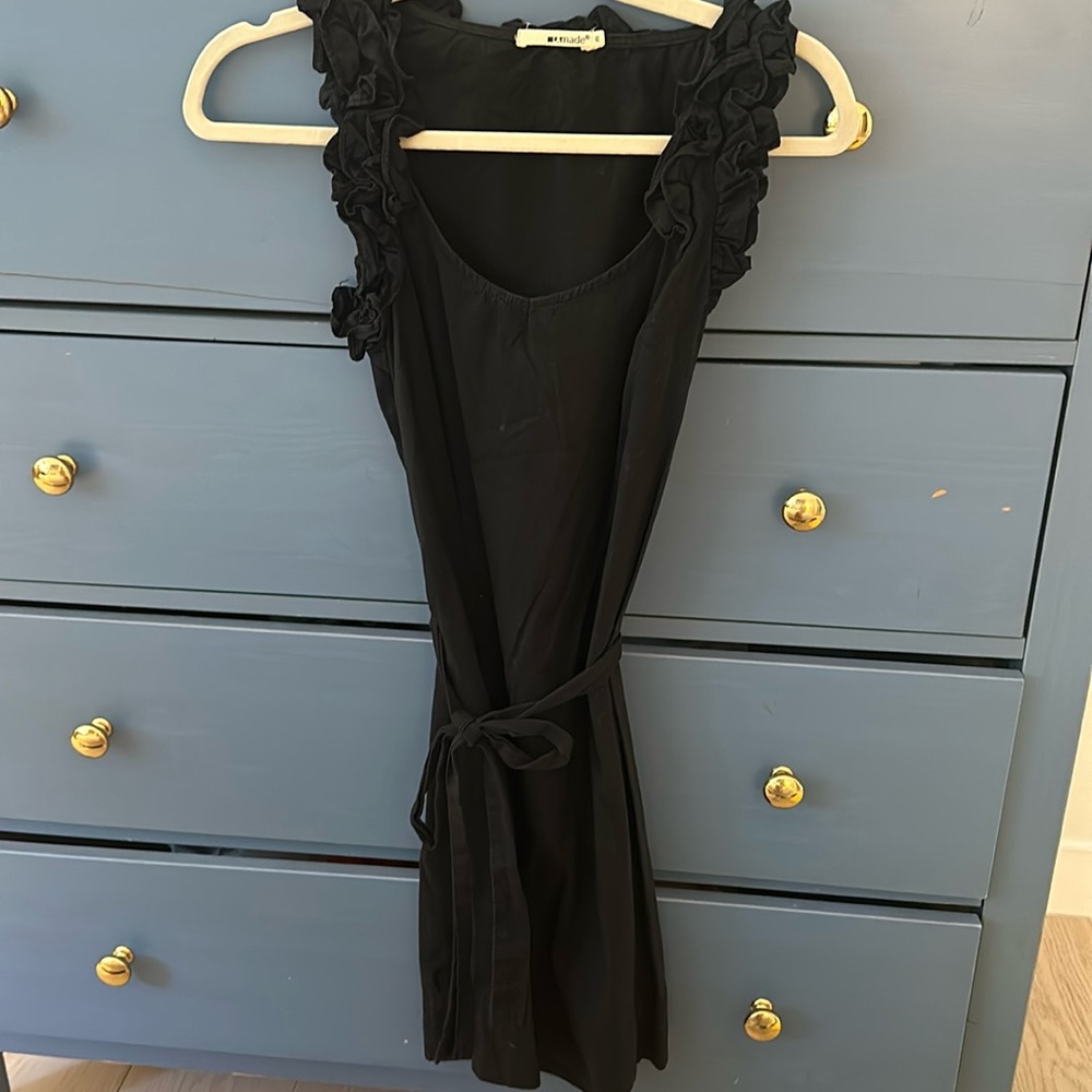 Black dress with waist tie and ruffle sleeves and neckline.